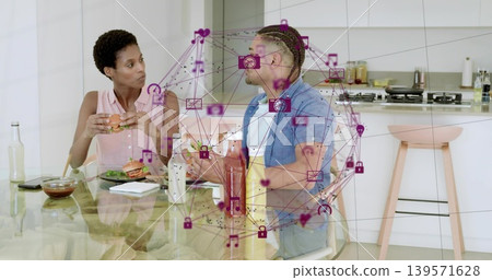Holding burger woman left and holding sandwich man right conversing at glass table, magenta overlay Holding burger woman left and holding sandwich man right conversing at glass table, magenta overlay 139571628