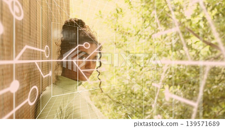 Standing woman in highneck top by slatted wall near foliage, with circuit graphics, 3D grid overlay Standing woman in highneck top by slatted wall near foliage, with circuit graphics, 3D grid overlay 139571689