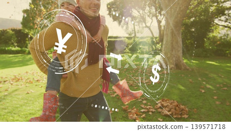 Walking father carrying child piggyback across park lawn, mustard sweater, showing yen dollar icons Walking father carrying child piggyback across park lawn, mustard sweater, showing yen dollar icons 139571718