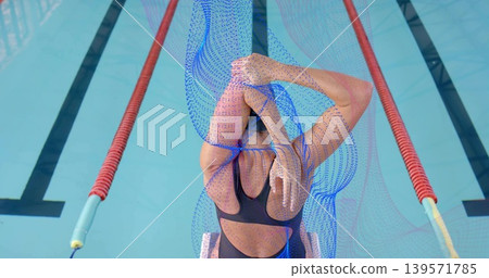 Stretching swimmer in dark one-piece and swim cap on starting block, with red ropes and overlay 139571785