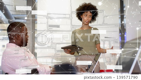 Presenting woman olive-top holding tablet and explaining to seated man at meeting table, holo UI Presenting woman olive-top holding tablet and explaining to seated man at meeting table, holo UI 139571790