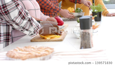 Chopping, four cooks wearing checked shirts and mustard top at kitchen counter with boards, pie 139571830
