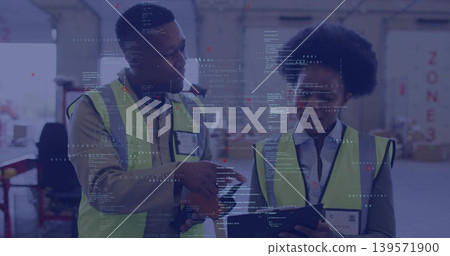 Pointing male worker and female worker reviewing tablet at warehouse with hi-vis vests, ID badges Pointing male worker and female worker reviewing tablet at warehouse with hi-vis vests, ID badges 139571900