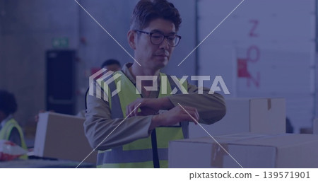 Inspecting mature Korean worker with glasses work shirt safety vest, handling boxes in loading bay 139571901