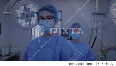 Standing surgical team preparing in operating room, wearing gowns, caps, masks, eyeglasses 139571949