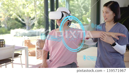 Guiding therapist in grey scrubs supporting patient with VR headset on treatment table, AR overlays Guiding therapist in grey scrubs supporting patient with VR headset on treatment table, AR overlays 139571967