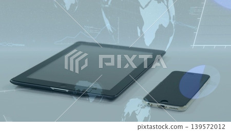 Displaying tablet showing holographic globe overlays on glossy tabletop with smartphone nearby 139572012
