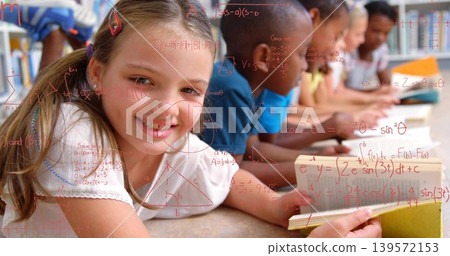 Reading smiling girl holding open book on school carpet, others studying red formulas, copy space Reading smiling girl holding open book on school carpet, others studying red formulas, copy space 139572153