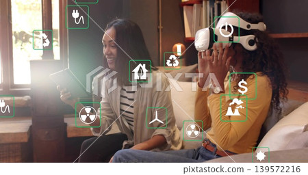Holding tablet women in mustard top adjusting VR headset green AR icons overlaying in living room Holding tablet women in mustard top adjusting VR headset green AR icons overlaying in living room 139572216