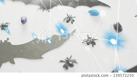 Showing black bat cutout on white tabletop, with spiders, blue-purple-black candy, network nodes Showing black bat cutout on white tabletop, with spiders, blue-purple-black candy, network nodes 139572250