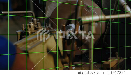 Rotating round workpiece touching tool bit at shop bench, with 3-jaw chuck, metal chips, green grid 139572341