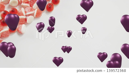 Floating purple 3D hearts drifting over white backdrop with red and white sugared gummies Floating purple 3D hearts drifting over white backdrop with red and white sugared gummies 139572368
