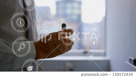 Pointing mid-adult man's right hand interacting with HUD at office window, with stylus, white cuff Pointing mid-adult man's right hand interacting with HUD at office window, with stylus, white cuff 139572439
