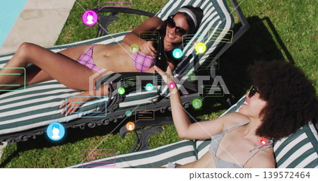 Reclining two women passing bottle on striped chairs by pool, with sunglasses and social icons Reclining two women passing bottle on striped chairs by pool, with sunglasses and social icons 139572464