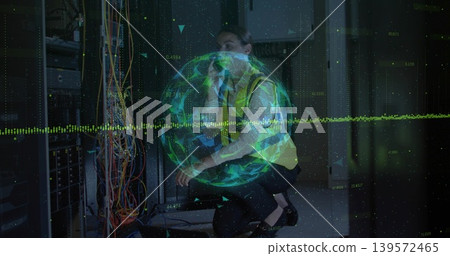 Kneeling mid-adult female tech routing multicolor cables at rack in hi-vis vest with green hologram Kneeling mid-adult female tech routing multicolor cables at rack in hi-vis vest with green hologram 139572465