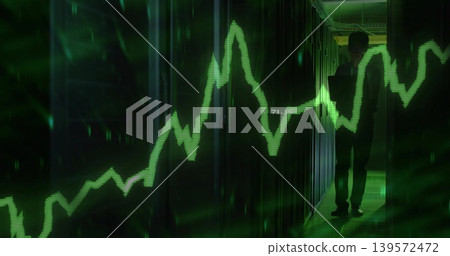 Monitoring IT pro in dark clothes holding tablet in server rack aisle, green waveform, copy space 139572472