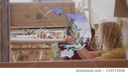 Holding camera, men in workshop, one in red plaid, other yellow tee steadying rail, map decal 139572488