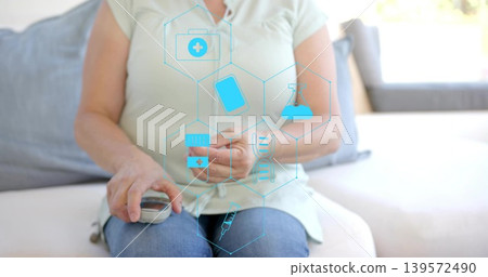 Adult woman testing finger and checking glucose with meter in living room, green top, jeans, icons Adult woman testing finger and checking glucose with meter in living room, green top, jeans, icons 139572490
