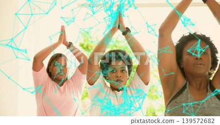 Performing three midlife women in activewear raising palms above heads at gym, with digital overlay Performing three midlife women in activewear raising palms above heads at gym, with digital overlay 139572682