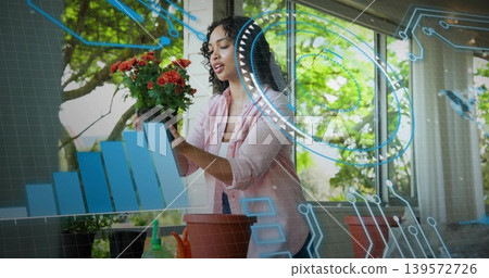 Checking woman in pink top placing orange-red plant on clay pot at potting table, data overlay Checking woman in pink top placing orange-red plant on clay pot at potting table, data overlay 139572726