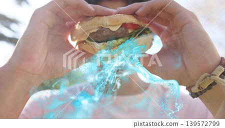Holding adult wearing pink tee lifting sesame burger to mouth at park, with cyan effect, bracelets Holding adult wearing pink tee lifting sesame burger to mouth at park, with cyan effect, bracelets 139572799