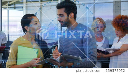 Gesturing man in grey sweater with open notebook leading office talk with green folder blue HUD Gesturing man in grey sweater with open notebook leading office talk with green folder blue HUD 139572952