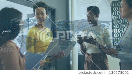 Presenting four women in office reviewing data with map overlays, yellow top holding laptop tablet Presenting four women in office reviewing data with map overlays, yellow top holding laptop tablet 139573001