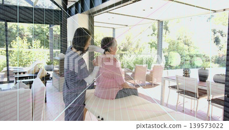 Massaging grey-scrub caregiver placing hands on pink-blouse client at home, treatment bench Massaging grey-scrub caregiver placing hands on pink-blouse client at home, treatment bench 139573022