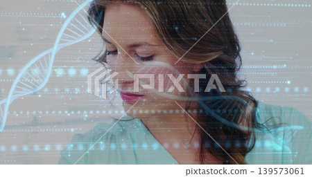 Looking adult woman wearing teal blouse tilting head down in studio, with DNA double-helix overlay Looking adult woman wearing teal blouse tilting head down in studio, with DNA double-helix overlay 139573061