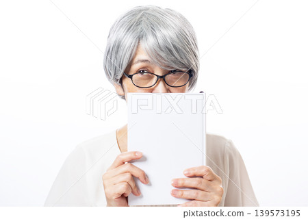 A senior woman with white hair, clearly eager to read. 139573195