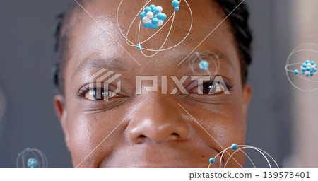 Showing African American woman with braids revealing skin texture in studio, with molecular orbits Showing African American woman with braids revealing skin texture in studio, with molecular orbits 139573401