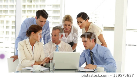 Discussing team reviewing laptop in meeting room with windows, notepad, coffee, in business attire 139573657