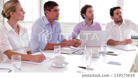 Sitting four colleagues in business casual clothing discussing project in meeting room, with laptop Sitting four colleagues in business casual clothing discussing project in meeting room, with laptop 139573659
