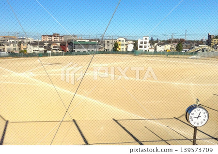 A scene of a blue sky, a clock, and a sports field. A scene of a blue sky, a clock, and a sports field. 139573709
