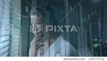 Standing man touching chin, gazing out window with blinds in office, overlaid charts Standing man touching chin, gazing out window with blinds in office, overlaid charts 139573722