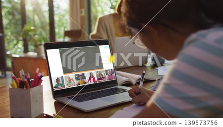 Writing child right of table studying with notebook, laptop on call, pencils at home, adult working 139573756