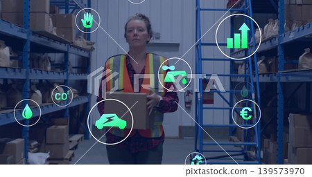 Walking worker carrying box in storage aisle wearing hivis vest over plaid shirt, blue racks, icons 139573970