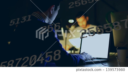 Working Asian man in dark sweater typing on laptop in dim office, with numeric overlays Working Asian man in dark sweater typing on laptop in dim office, with numeric overlays 139573980