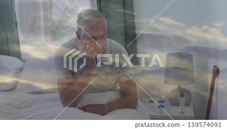 Sitting elderly man resting head, gazing on bed in striped polo, with pills, cane, cloud overlay 139574091