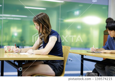 看到女學生在教室裡認真學習。 看到女學生在教室裡認真學習。 139574215