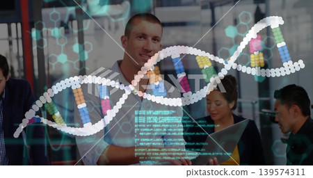 Standing man leading meeting in glass room, in business-casual, open laptop and DNA overlay visible Standing man leading meeting in glass room, in business-casual, open laptop and DNA overlay visible 139574311