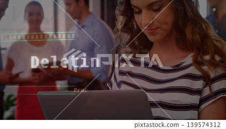 Typing woman in striped shirt using open laptop in office, with Deletin overlay and smartphones Typing woman in striped shirt using open laptop in office, with Deletin overlay and smartphones 139574312