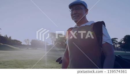 Walking golfer carrying golf bag on fairway, showing clubs, flat cap, vest, glasses, copy space Walking golfer carrying golf bag on fairway, showing clubs, flat cap, vest, glasses, copy space 139574361