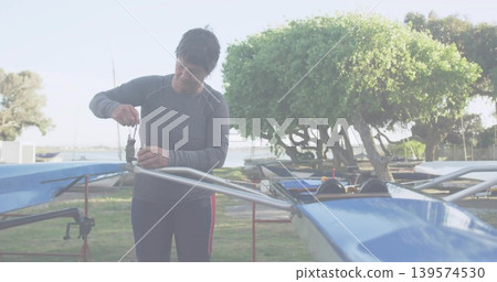 Working woman fixing rigging on blue shell at boatyard wearing gray top red leggings holding wrench Working woman fixing rigging on blue shell at boatyard wearing gray top red leggings holding wrench 139574530
