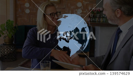 Shaking hands, two men in gray suit and dark sweatshirt exchanging tablet at office, hologram Shaking hands, two men in gray suit and dark sweatshirt exchanging tablet at office, hologram 139574629