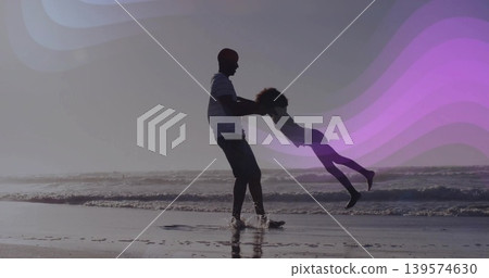 Swinging father holding daughter by hands at ocean shoreline, striped shirt, purple wave overlays Swinging father holding daughter by hands at ocean shoreline, striped shirt, purple wave overlays 139574630