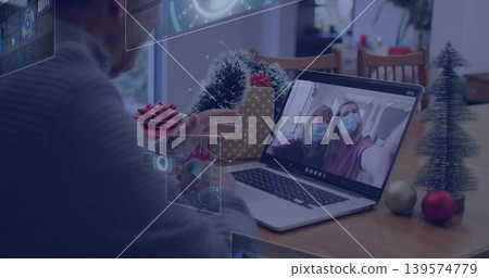Sitting senior man in grey sweater operating laptop at dining table, showing AR UI panels Sitting senior man in grey sweater operating laptop at dining table, showing AR UI panels 139574779