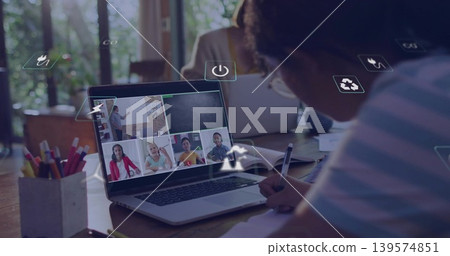 Writing student wearing striped top, glasses taking notes at home table with laptop, copy space Writing student wearing striped top, glasses taking notes at home table with laptop, copy space 139574851