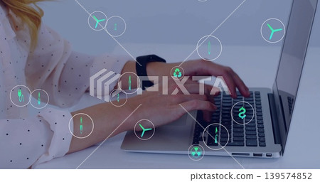 Typing woman wearing dotted blouse, black smartwatch at white desk on laptop, showing green icons Typing woman wearing dotted blouse, black smartwatch at white desk on laptop, showing green icons 139574852