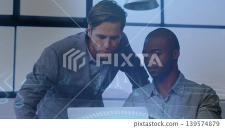 Leaning two men in business attire studying laptop at office with grid windows, HUD Leaning two men in business attire studying laptop at office with grid windows, HUD 139574879
